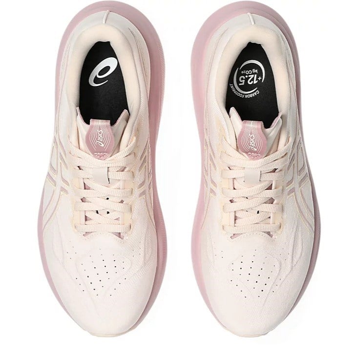 Pair of light pink sneakers with white soles on a white background