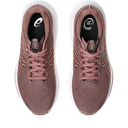 Pair of pink running shoes with white soles on a white background