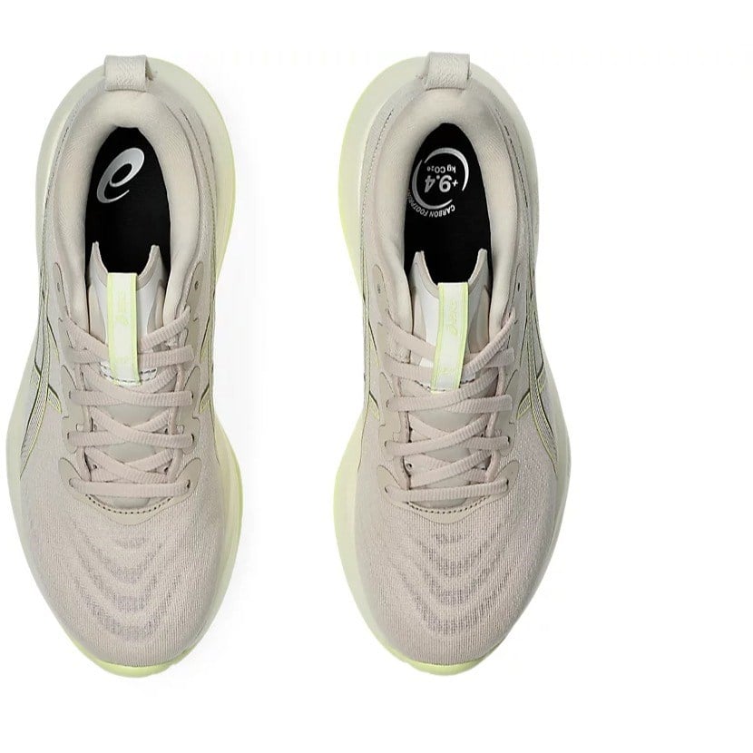 Pair of light gray athletic shoes with yellow accents on a white background