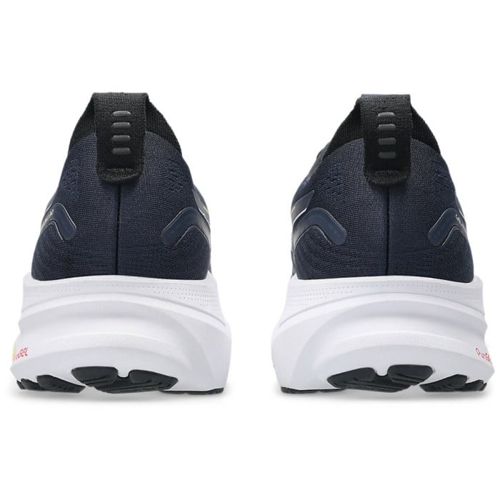 Navy running shoes with white soles on a white background