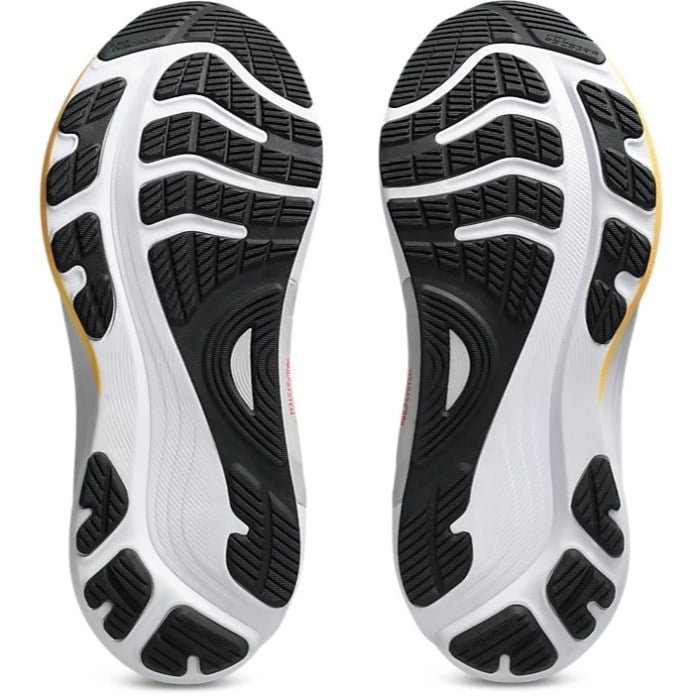Close-up of a pair of white and black athletic shoes with tread pattern on a white background