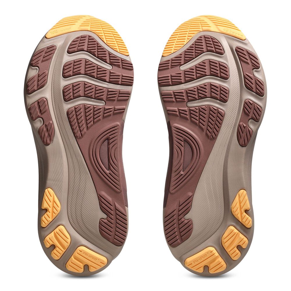 Close-up of a pair of shoes with brown and yellow soles on a white background