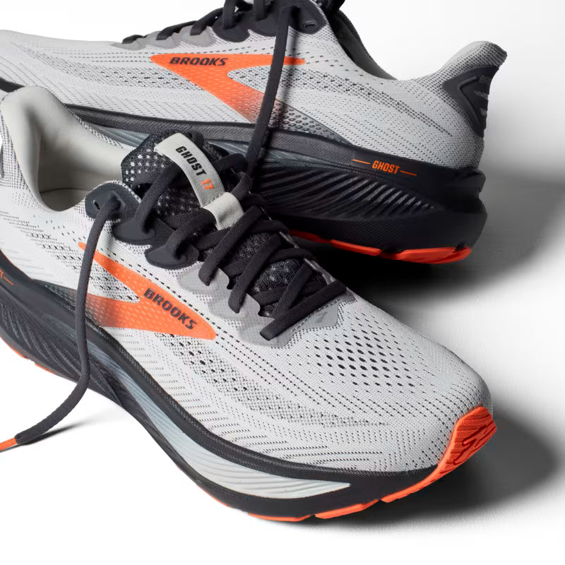 Gray and orange running shoes with 'Brooks' branding on a light gray background