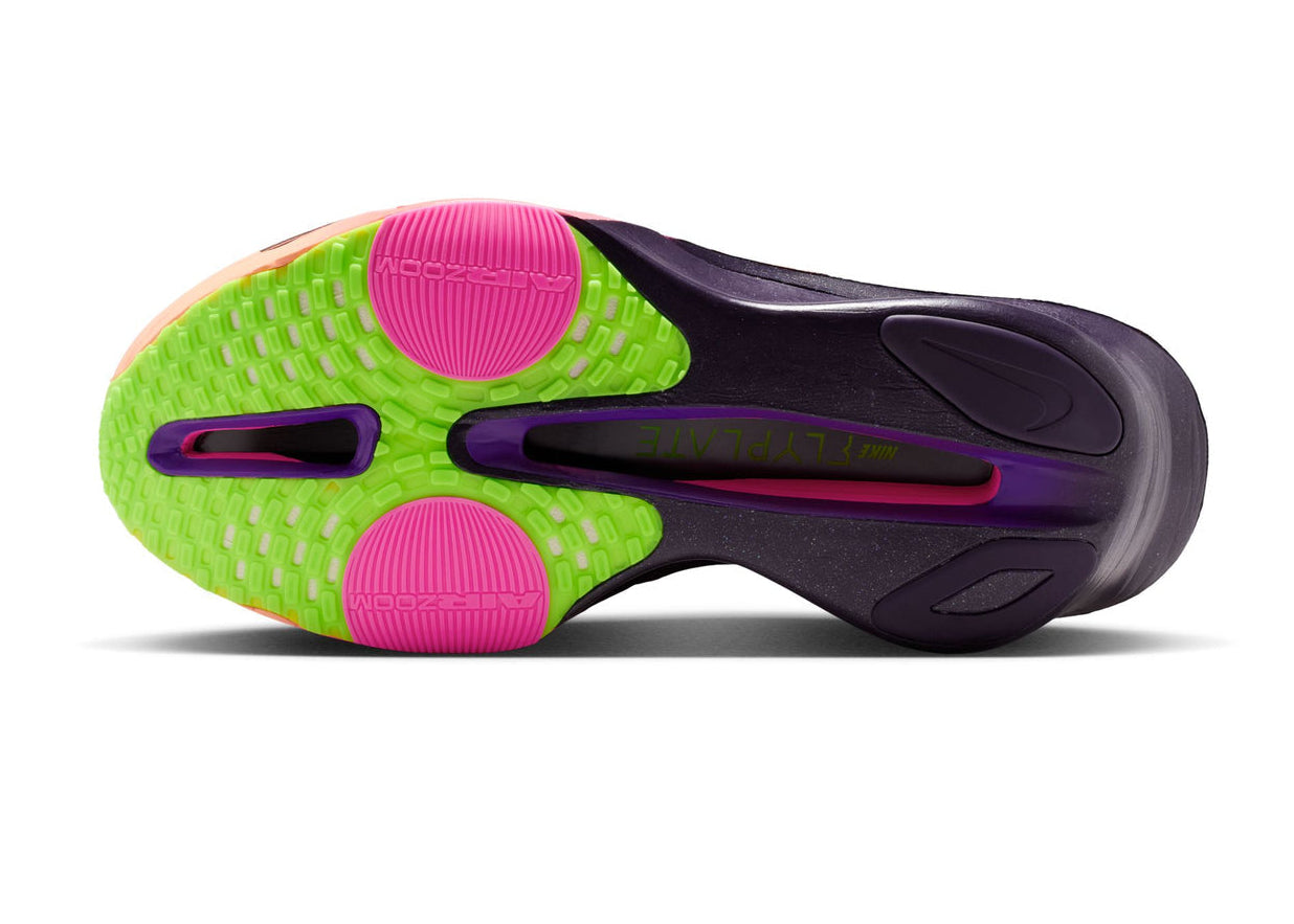 Close-up of a shoe sole with green, pink, and purple colors on a white background