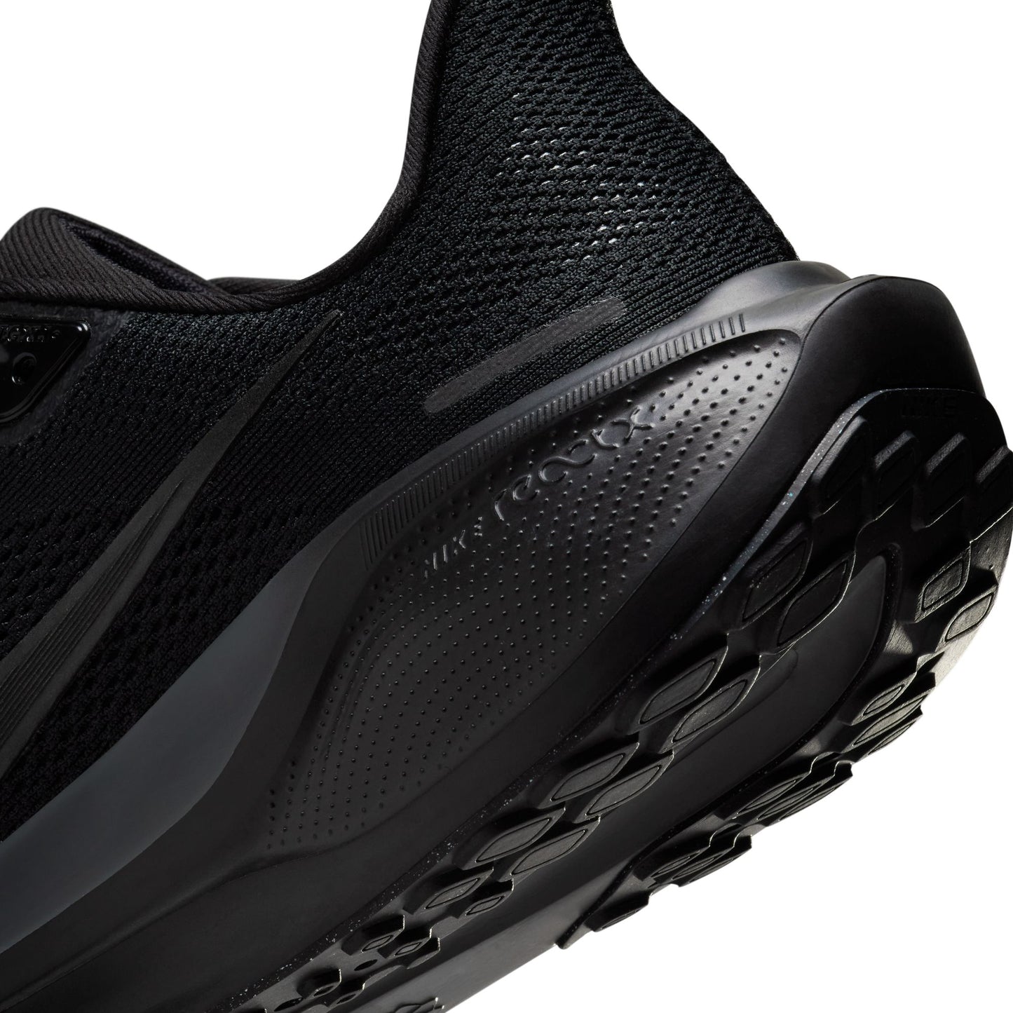 Close-up of a black athletic shoe with sole detail on a white background