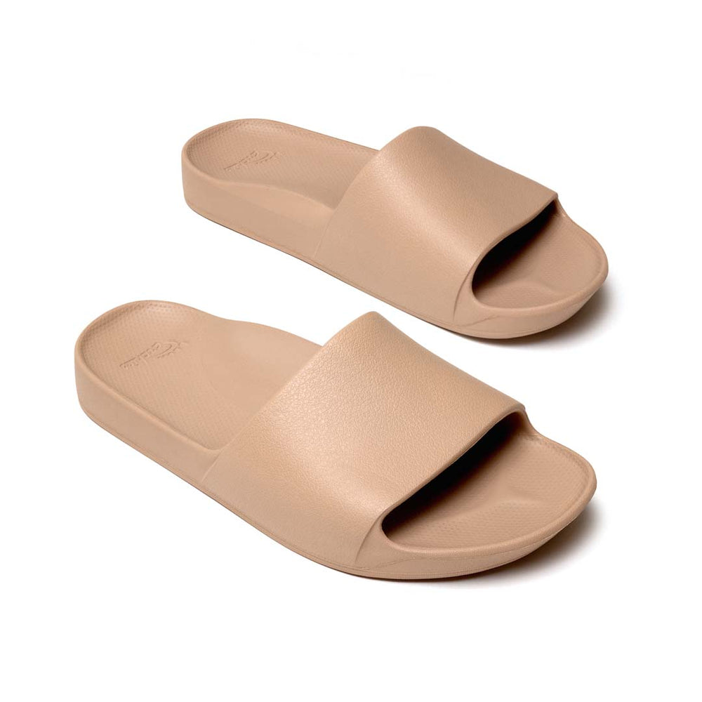 Pair of beige slides on a white background