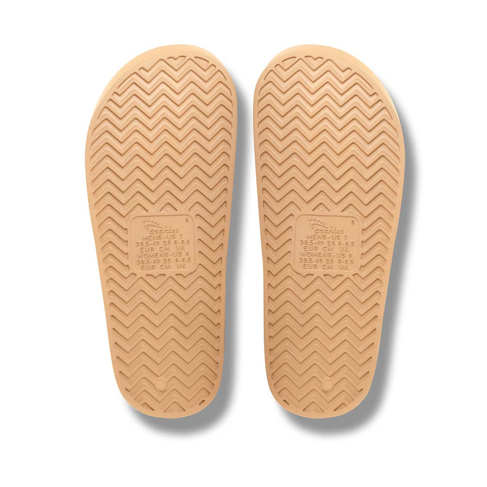 Beige shoe insoles with tread pattern on a white background