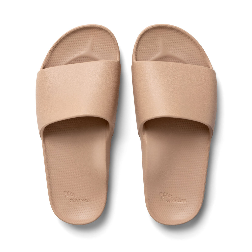 Pair of beige slides on a white background