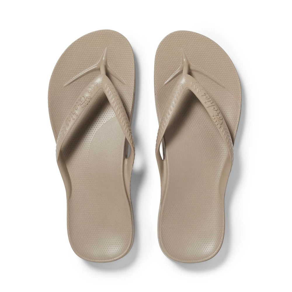 Pair of beige flip-flops on a white background