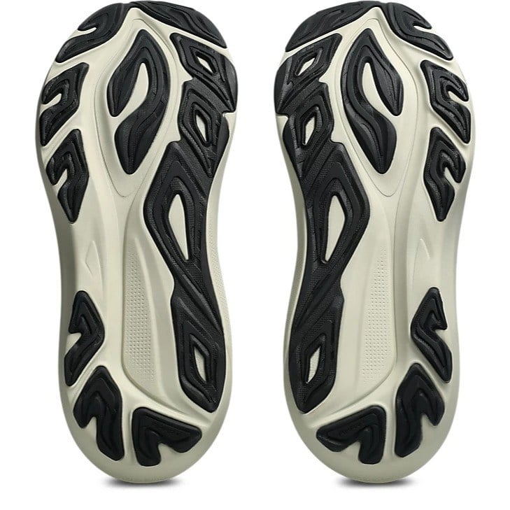 Close-up of a pair of white and black athletic shoes with unique sole design on a white background