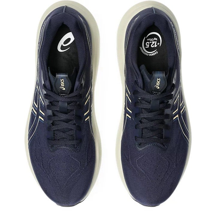 Pair of navy blue running shoes with white soles on a white background