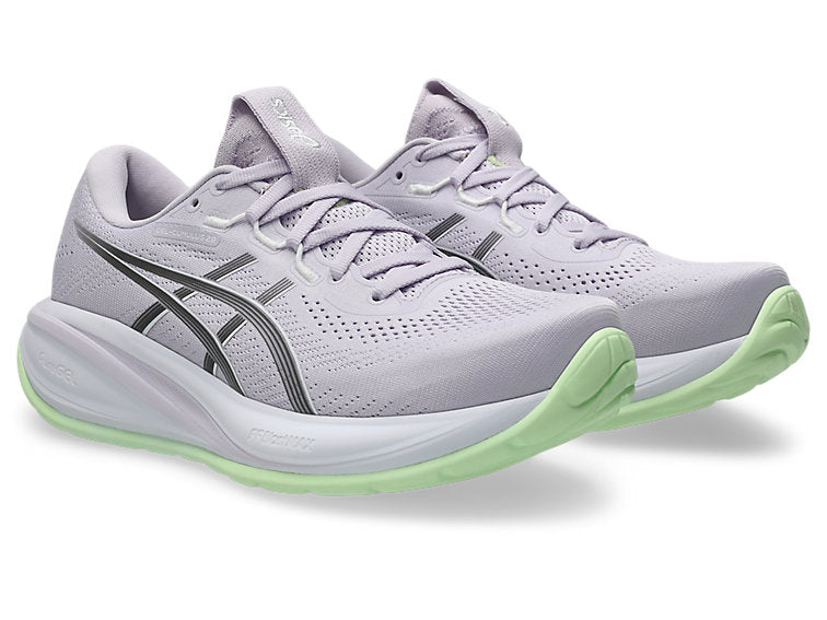Light purple running shoes with green soles on a white background