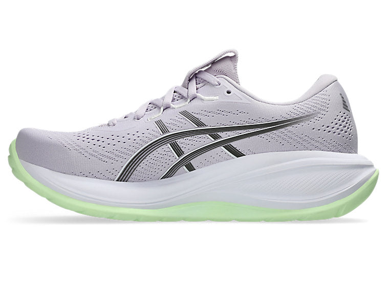 White running shoe with green sole on a white background