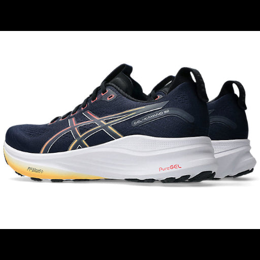 Navy running shoe with white sole on a white background
