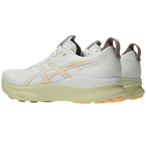 White running shoes with yellow accents on a white background