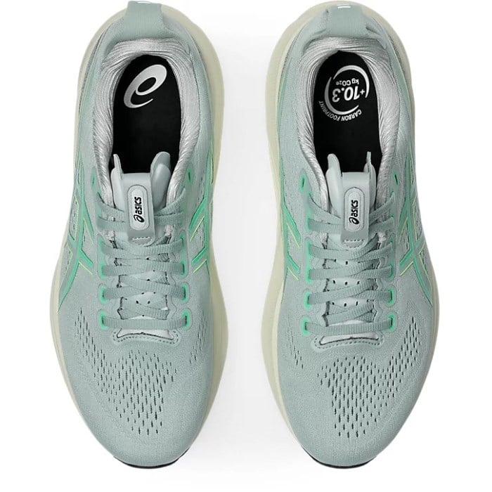 Pair of light blue running shoes with white laces on a white background