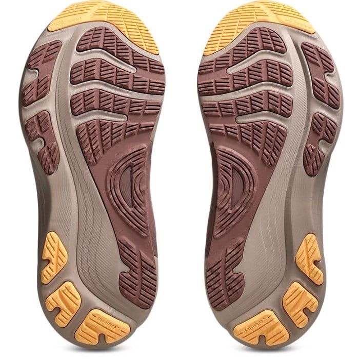 Close-up of the sole of a shoe with brown and yellow tread pattern on a white background