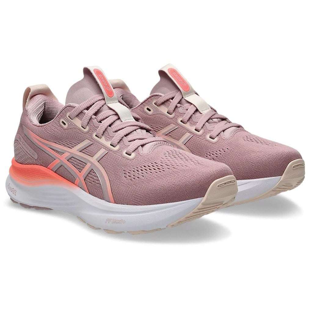 Pair of pink running shoes with white soles on a light gray background