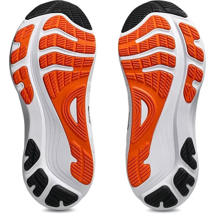 Close-up of a pair of running shoes with orange and black sole design on a white background