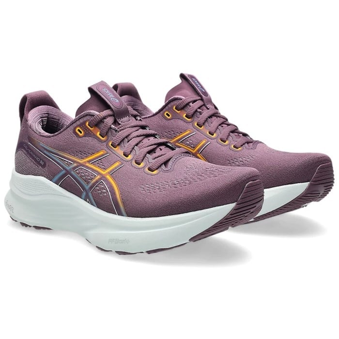Pair of purple running shoes with white soles on a white background