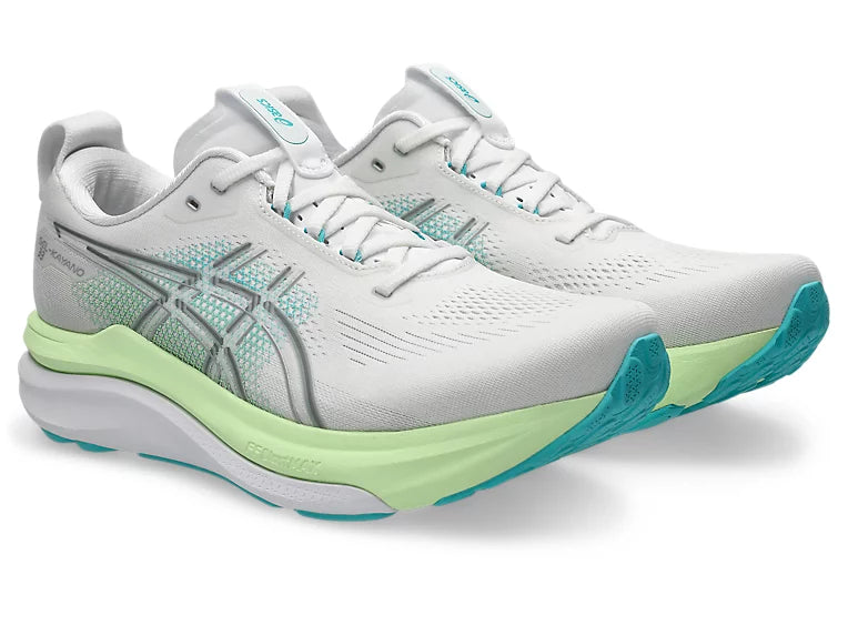 White running shoes with green and blue accents on a white background