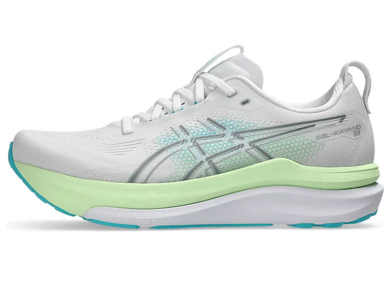 White running shoe with green sole on a white background
