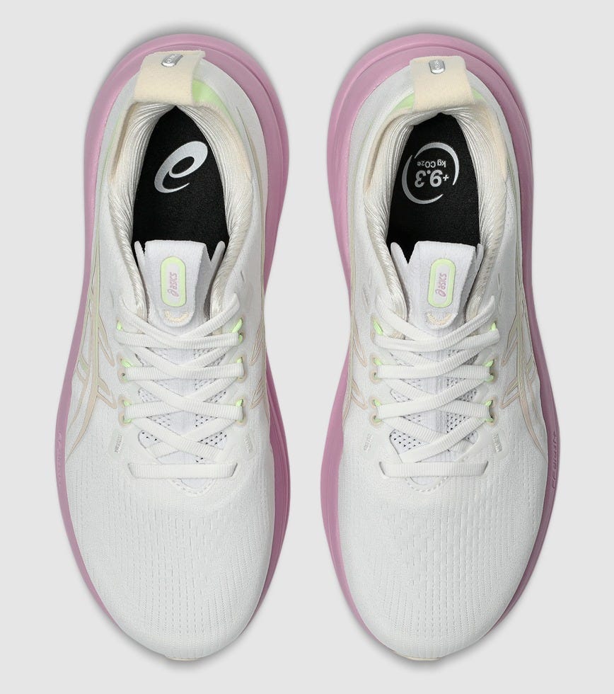 White running shoes with pink accents on a light gray background