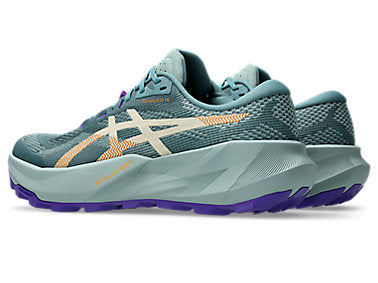 A pair of Asics running shoes in a muted teal colorway, featuring a textured mesh upper, a thick sculpted midsole, and purple and orange accents on the outsole and logo.