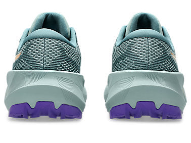 A pair of trail running shoes shown from the rear, featuring a textured teal-green mesh upper, a thick light gray-green midsole, and a contrasting purple outsole.