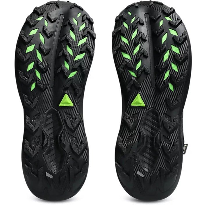 Close-up of black hiking shoes with green accents on a white background