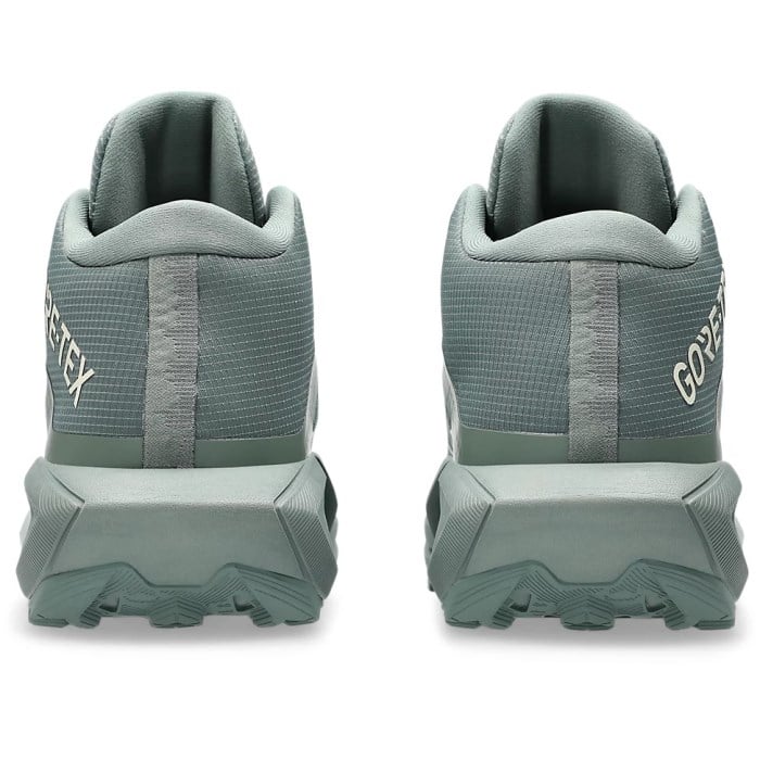 Pair of green hiking shoes with GORE-TEX branding on a white background