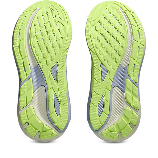 Close-up of green running shoes with tread pattern on a white background