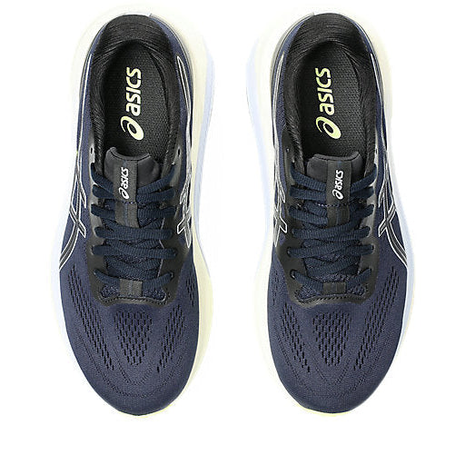 Pair of navy running shoes with white sole on a white background