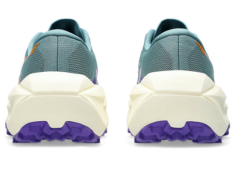 A pair of trail running shoes shown from the rear, featuring a teal mesh upper, a thick cream-colored midsole, and a purple outsole.