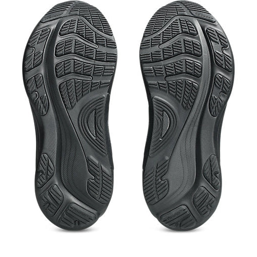 Close-up of black shoe soles with tread pattern on a white background