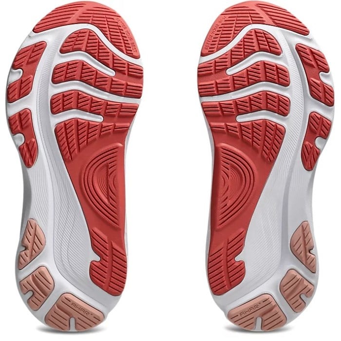 Close-up of red and white athletic shoe soles on a light gray background