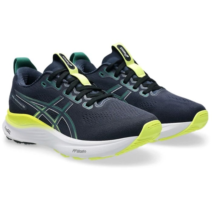 Navy running shoes with green accents on a white background