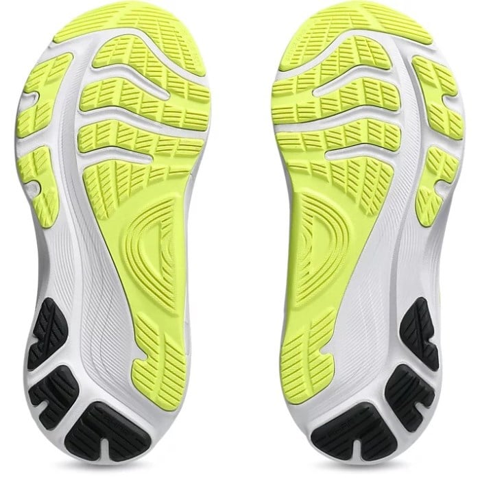 Close-up of a running shoe sole with white, green, and black design on a white background