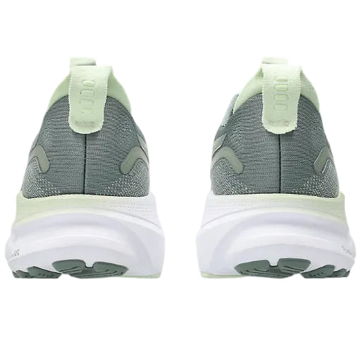Gray and green running shoes with white soles on a white background