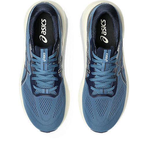 Pair of blue running shoes with white soles on a white background