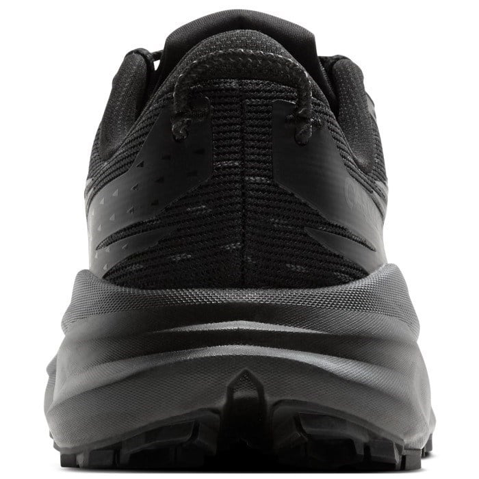 Black and gray athletic shoe with textured sole on a white background