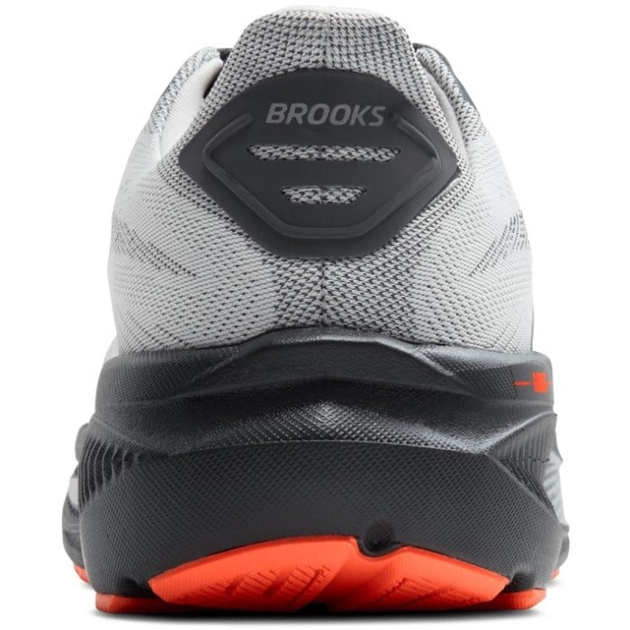 Back view of a gray and black running shoe with red sole on a white background