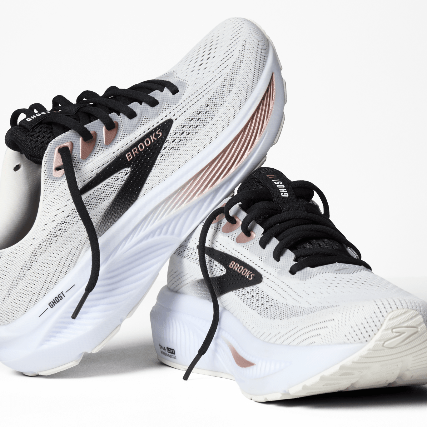 White running shoes with black laces and 'Brooks' branding on a white background