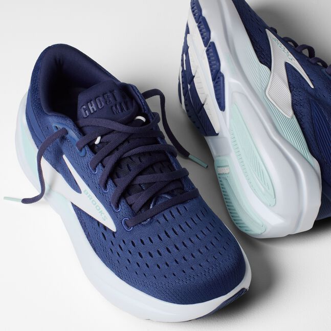Blue running shoes with white soles on a light gray background