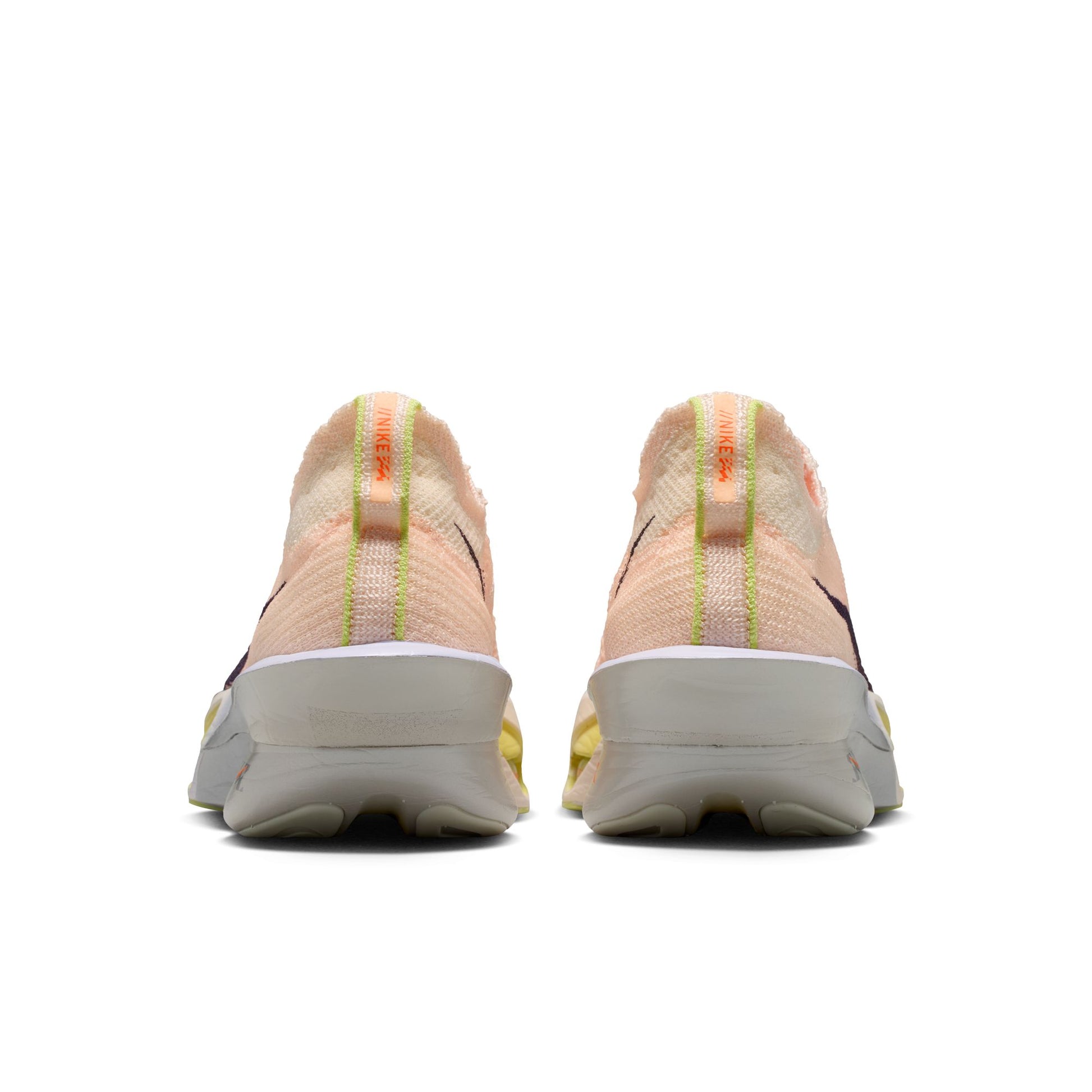 Pair of peach-colored running shoes with a white sole on a white background