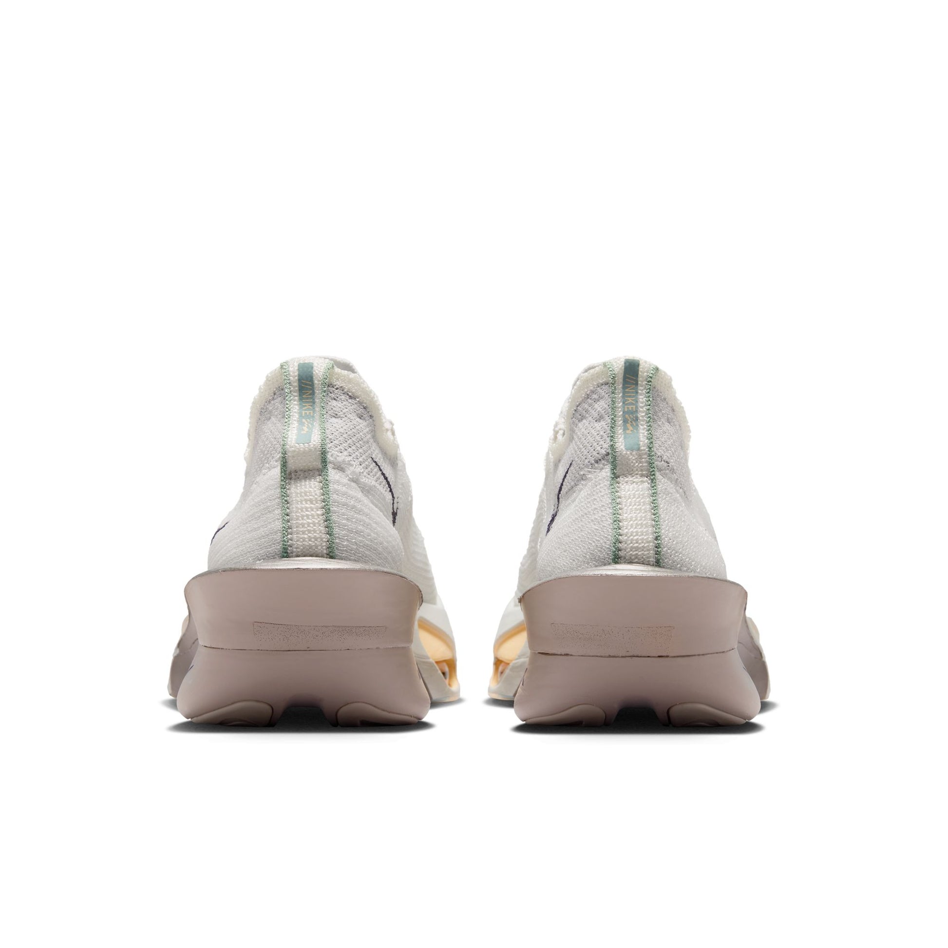 Back view of white sneakers with green accents on a white background
