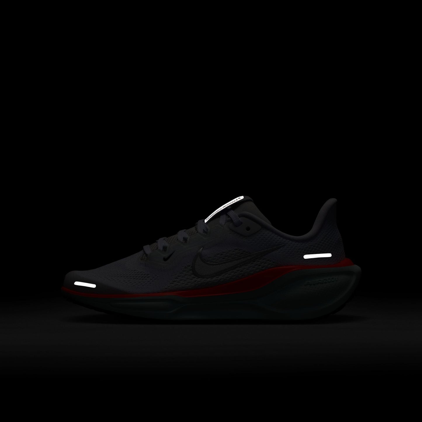 Black running shoe with reflective elements on a black background