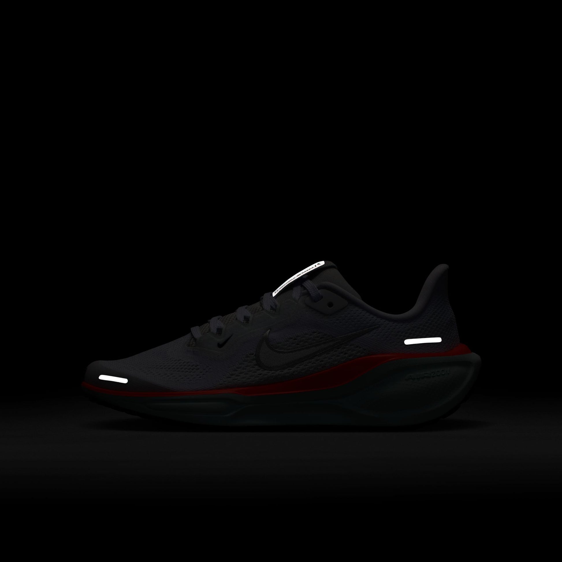 Black running shoe with reflective elements on a black background