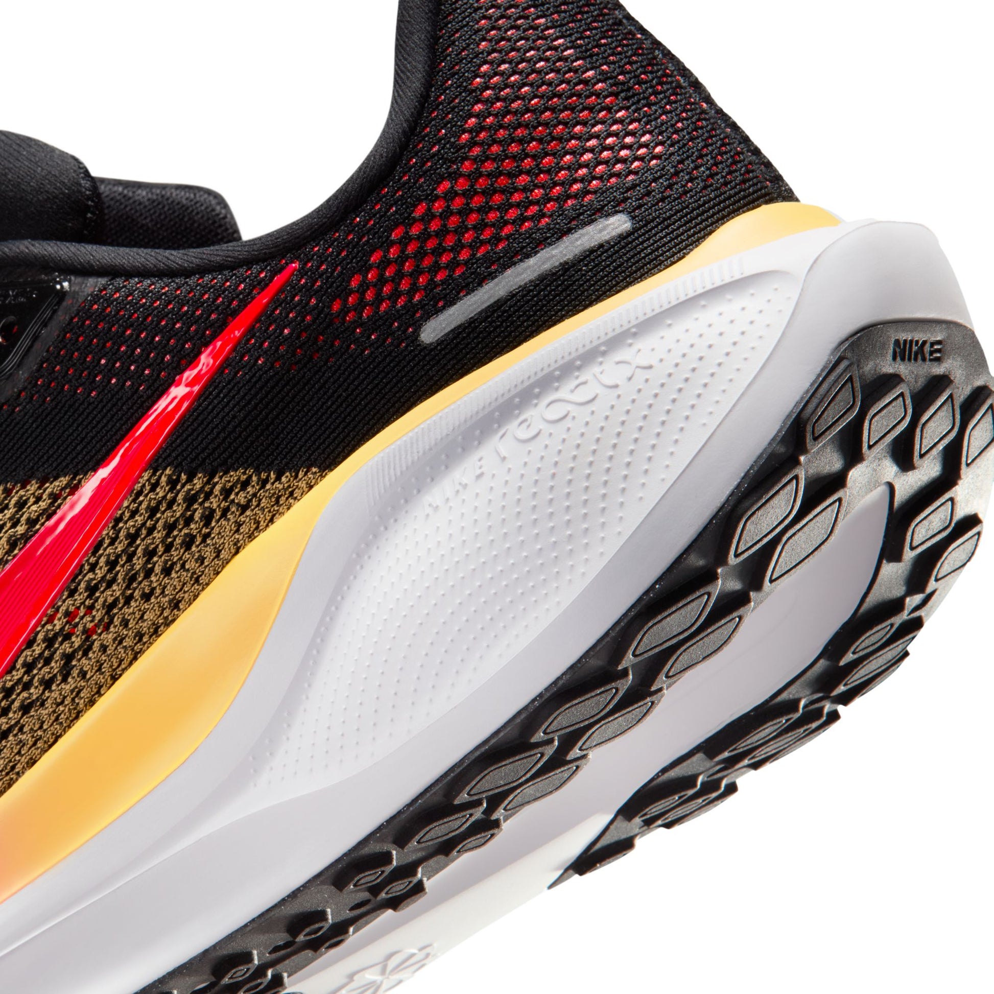 Close-up of a Nike running shoe with black, red, and yellow design on a white background