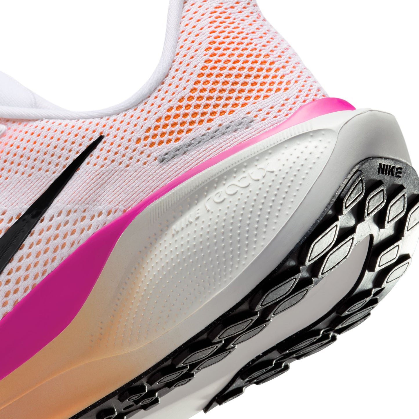 Close-up of a Nike running shoe with pink and orange accents on a white background